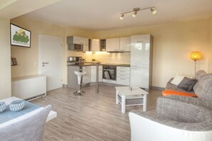 A compact living space with a kitchenette, a dining area, and a seating area. - Holiday home in Floh-Seligenthal with sauna (Floh-Seligenthal)