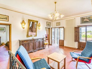 Un'ampia zona giorno con un grande specchio, un lampadario e vista panoramica tramite una porta in vetro.