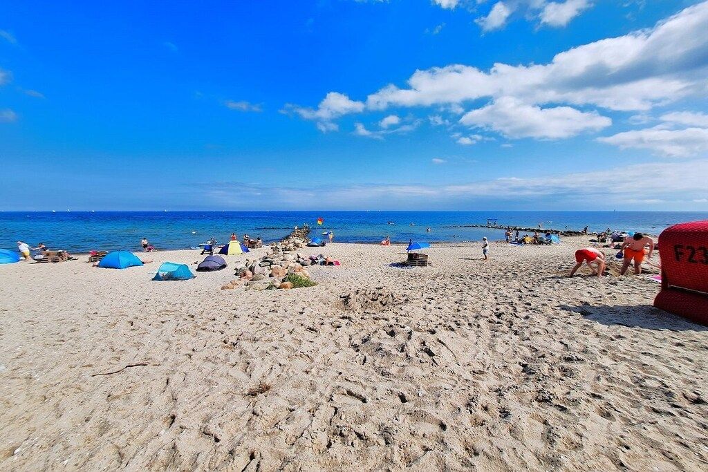 Una playa con tiendas de campaña y gente.