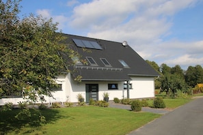 A single-story house with a sloped roof, solar panels, and a small front porch. - Holiday apartment with 2 bedrooms (Heidesee)