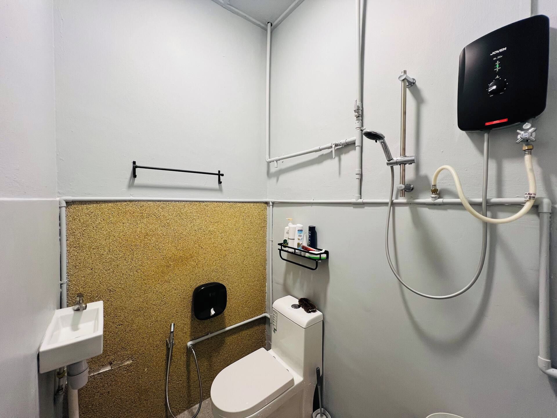Un baño pequeño con inodoro, ducha y lavamanos.