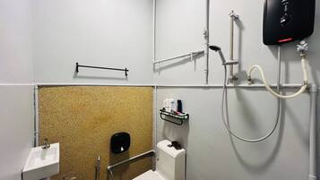 Un baño pequeño con inodoro, ducha y lavamanos.