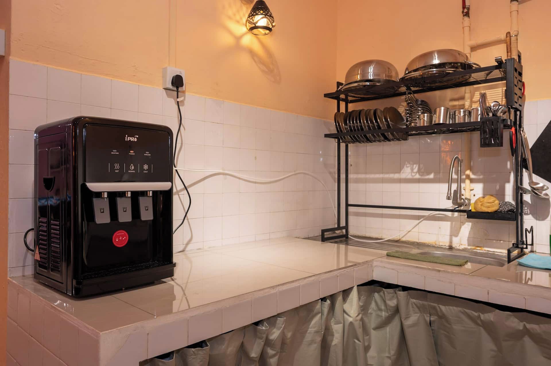 A kitchen with a coffee machine, a sink, and a dish rack.