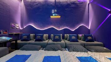 Una habitación con cama, escritorio y proyector instalado en la pared.