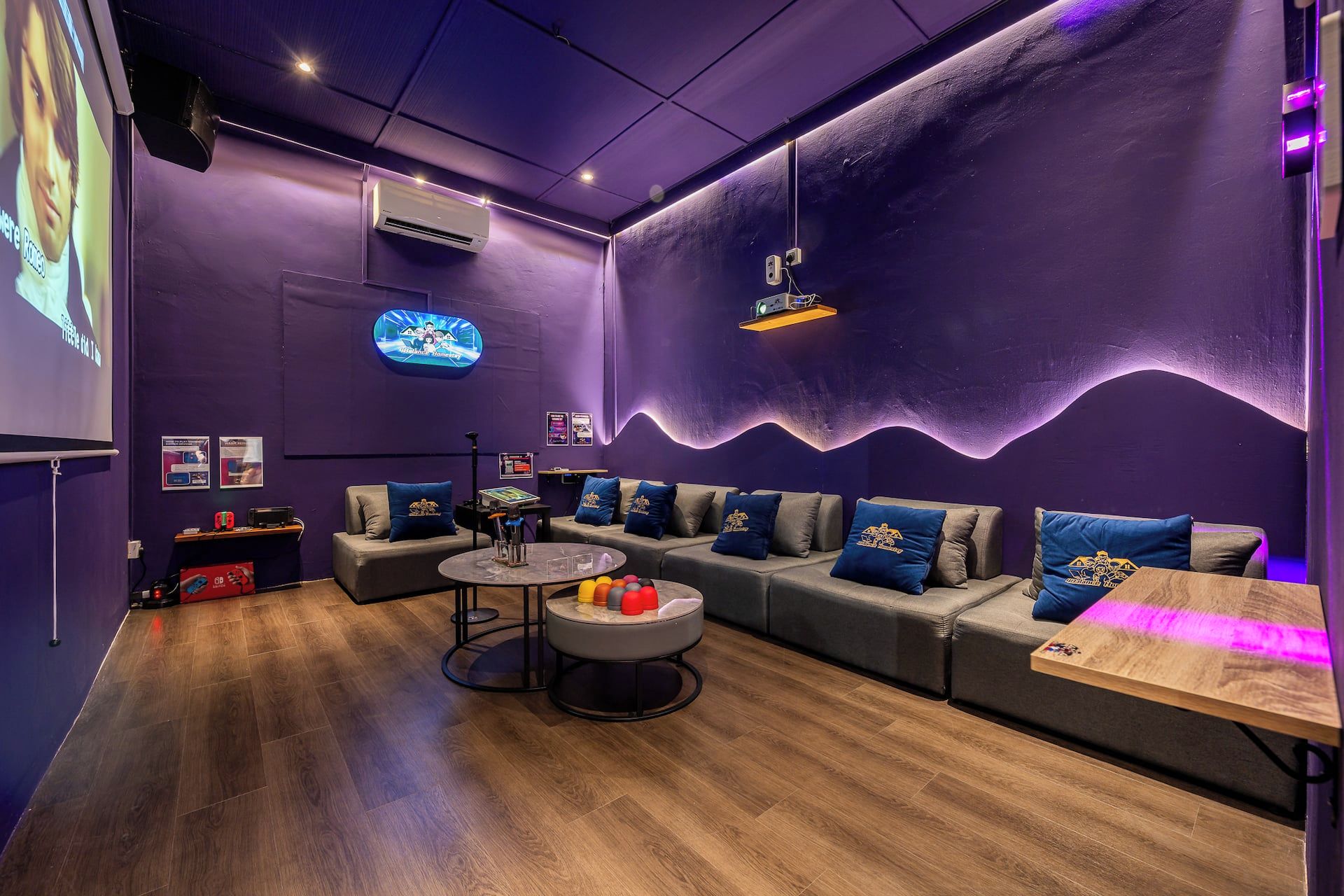 A modern lounge area with sofas, a coffee table, and a projector screen.