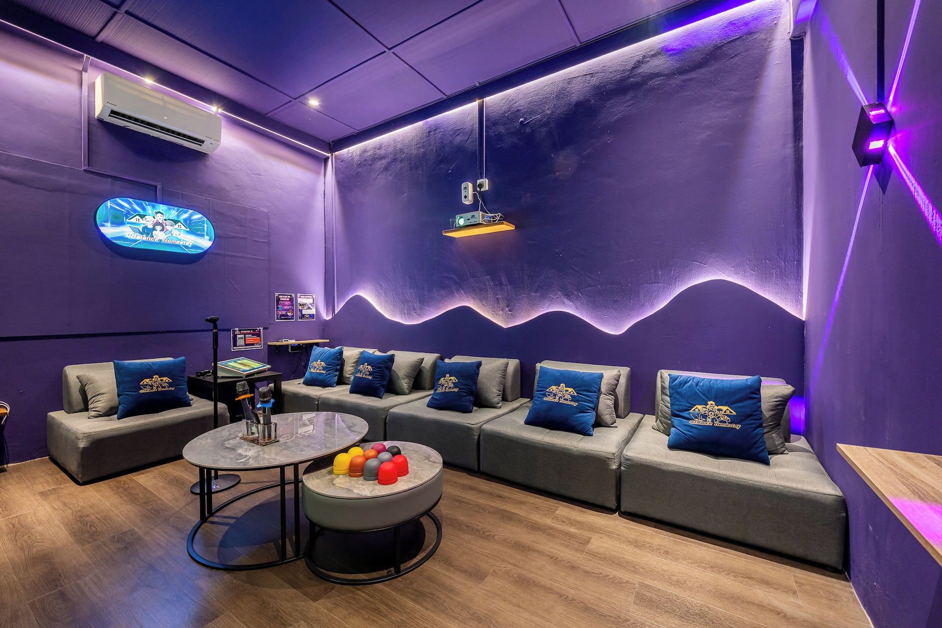 A room with a sofa set, a small table, and a projector screen.