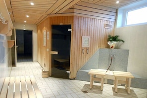 A sauna room with wooden walls, a bench, and a potted plant. - Dambach with lake view (Füssen)