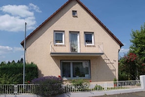 A two-story house with a balcony, a small window on the upper floor, and a number '20' on the facade. - Holiday home with 3 bedrooms (Braunfels)