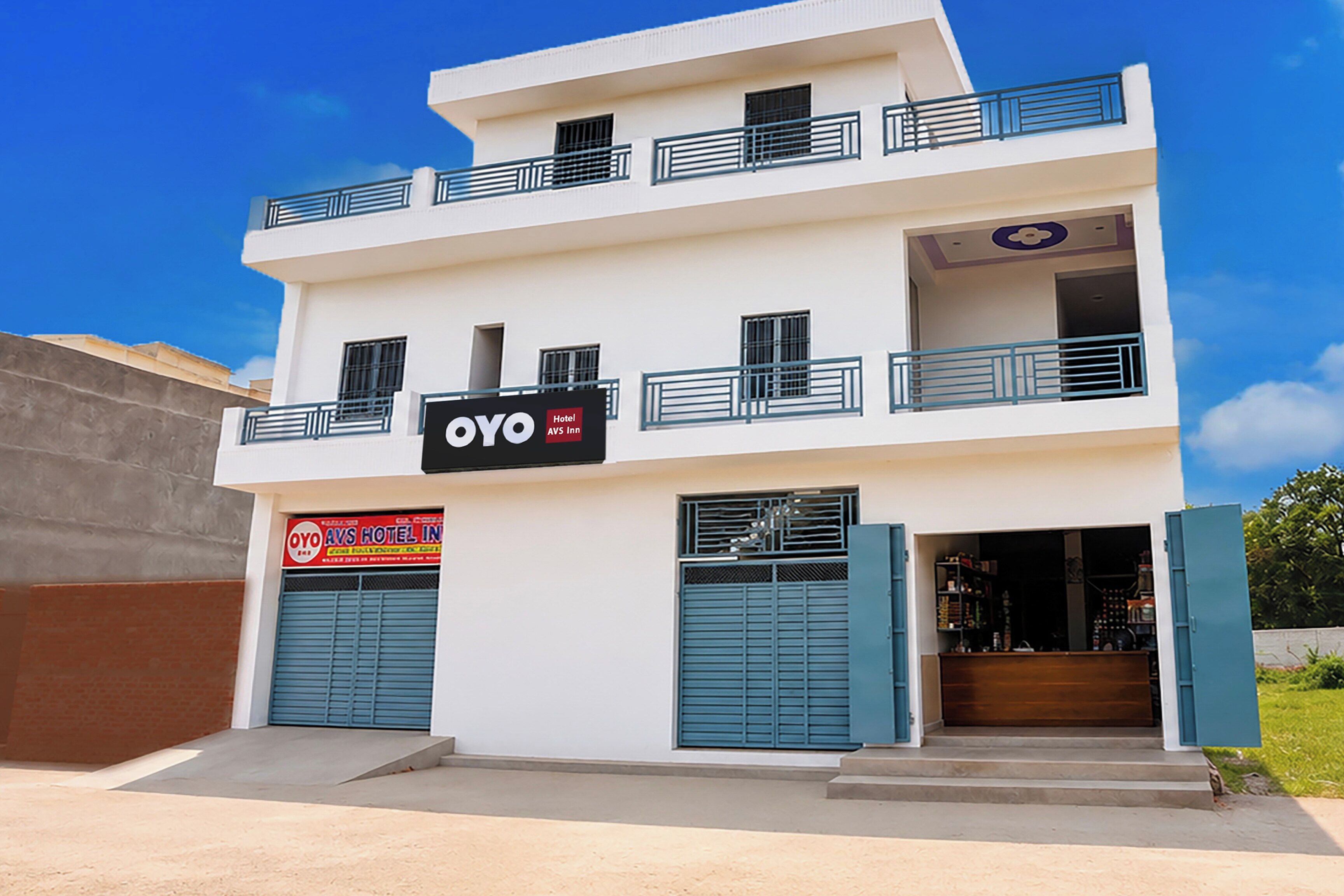 Un hotel de dos pisos con un letrero de OYO AVS Inn.