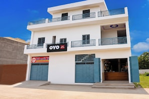 Un hotel de dos pisos con un letrero de OYO AVS Inn.