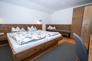 Ein modernes Schlafzimmer mit einem Holzbett, einer Bank und einem Kleiderschrank.