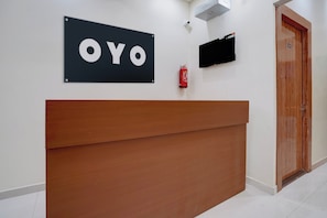 Ein Empfangsschalter mit einem Schild mit der Aufschrift 'OYO' und einem an der Wand befestigten Feuerlöscher.