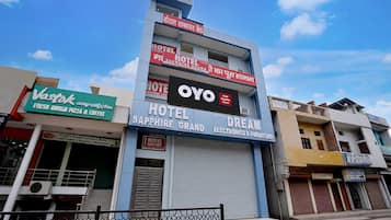 Un hotel con un letrero que dice 'Hotel Sapphire Grand' y 'Dream Electronics & Furniture' en la fachada.