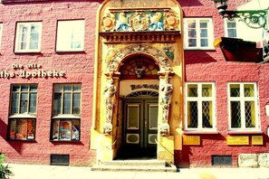 A red brick building with ornate architectural details, including a decorative archway and a sign that reads 'Die Apotheke.' - Bella Rosa **** Lüneburg (Lüneburg)