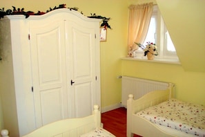 A child's bedroom with a white wardrobe, a small window with curtains, and a radiator. - Bella Rosa **** Lüneburg (Lüneburg)