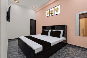 A modern bedroom with a bed, a flat-screen TV, and artwork on the wall. - Hotel O Priceless Lucknow (Lucknow)
