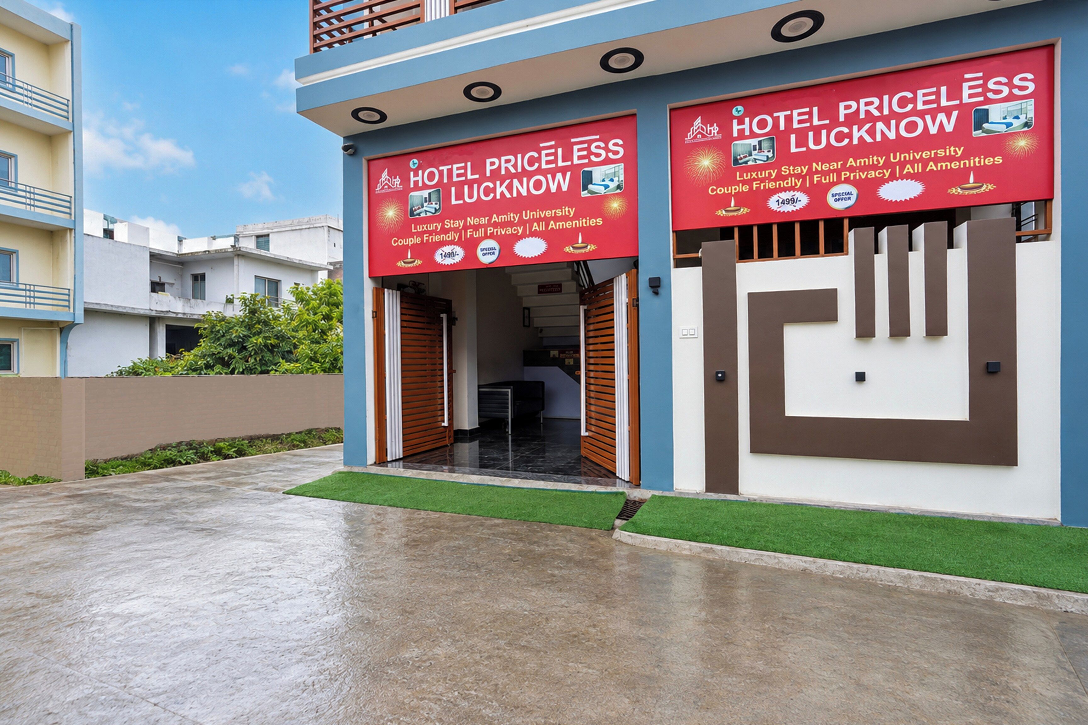 Un hotel con un letrero rojo que anuncia 'Hotel Priceless Lucknow' y 'Estancia de Lujo Cerca de la Universidad Amity', con comodidades como privacidad total y todos los servicios.