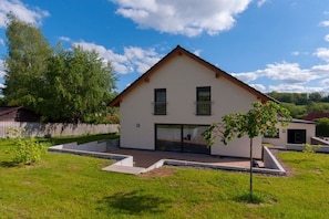 A modern two-story house with a flat roof, large windows, and a small front yard with a tree. - Holiday home South Harz (Neustadt\/Harz)