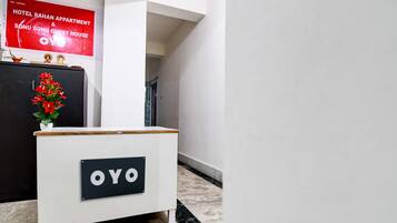 Una mesa de recepción con un letrero que dice 'OYO' en el vestíbulo de un hotel.