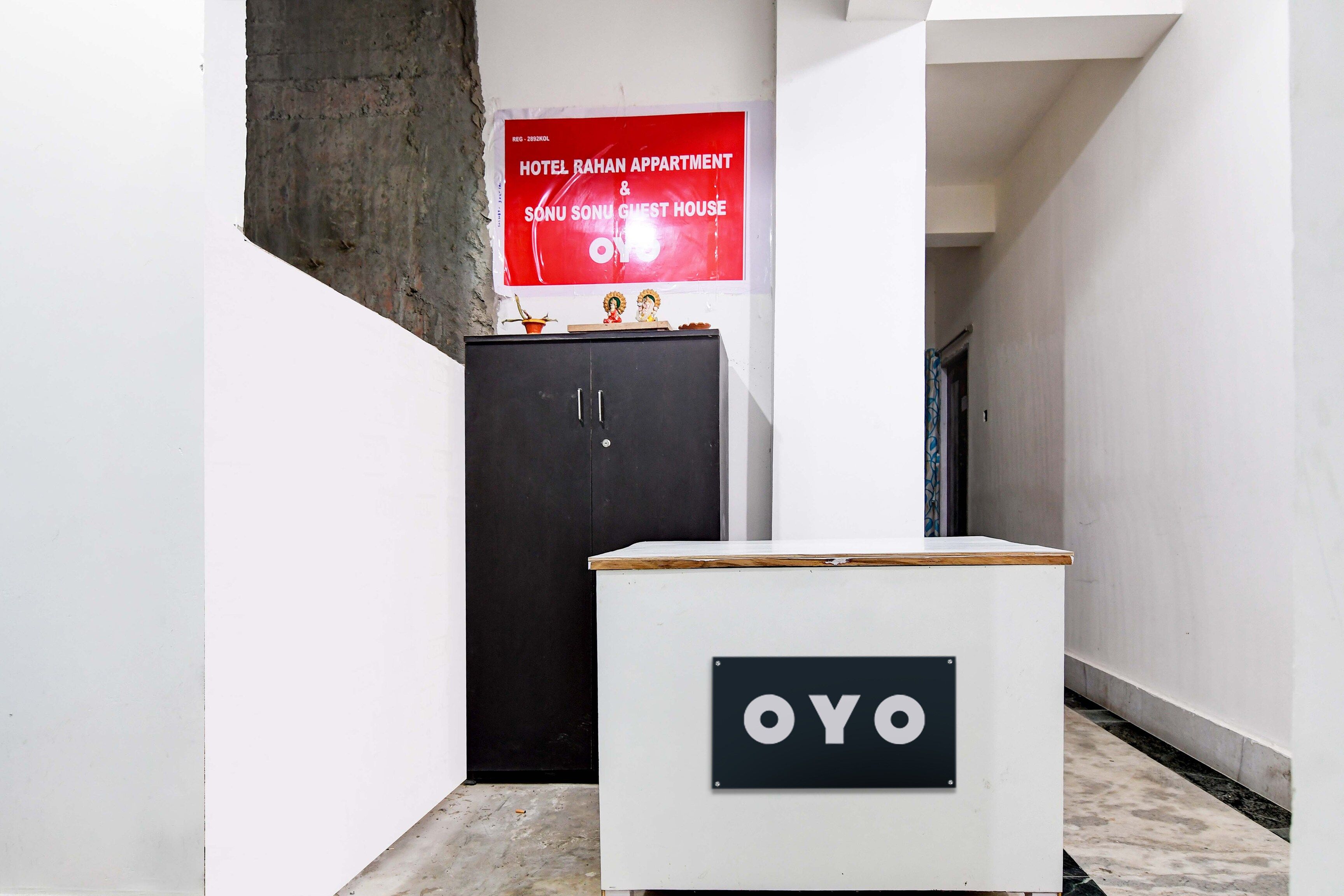 A corridor with a black cabinet and a white podium with 'OYO' branding.