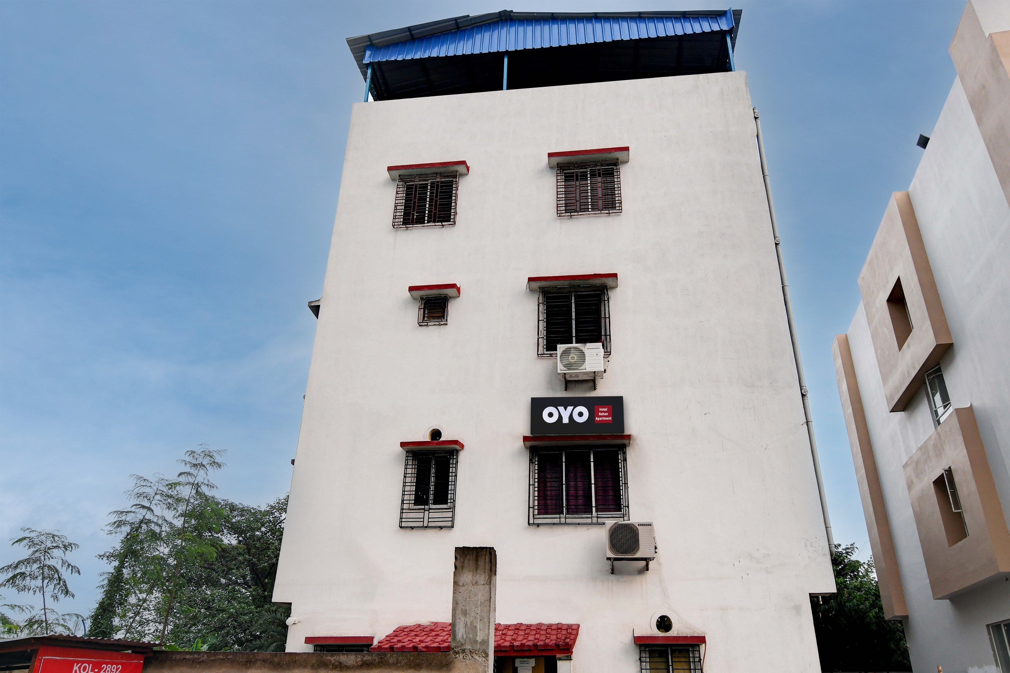 Un edificio de varios pisos con un letrero que indica que es un hotel llamado 'OYO Hotel Rahan Apartment'.