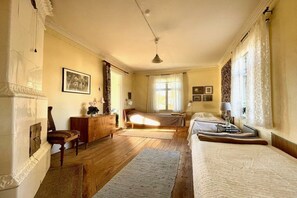 A room with two beds, a wooden floor, a dresser, a chair, and a window with curtains. - Holiday home in Tenhult with swimming pool (Tenhult)