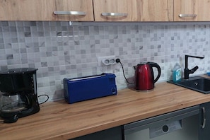 A kitchen with a coffee maker, toaster, kettle, and a dishwasher. - Villa Panorama Montenegro (Bar)