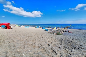 A beach with tents and a red vehicle. - Holiday apartment with 2 bedrooms (Schönhagen)