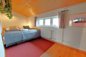 A room with a bed, a window with curtains, a radiator, and a wall-mounted shelf. - Holiday home in Geel with swimming pool (Geel)