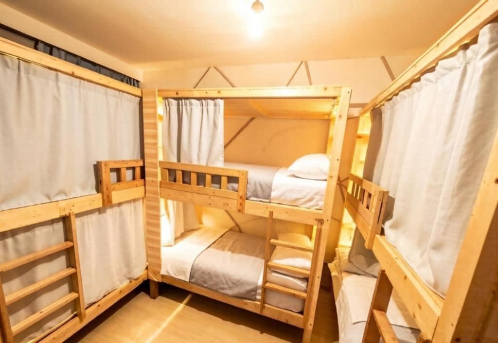 A bunk bed room with wooden frames, curtains, and a light fixture.
