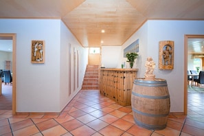 A hallway with a wooden barrel sculpture, a staircase, and wall-mounted artwork. - Holiday apartment in Minheim with barbecue (Minheim)