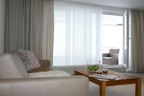 Un salon moderne avec un canapé, une table basse et une vue sur un balcon.