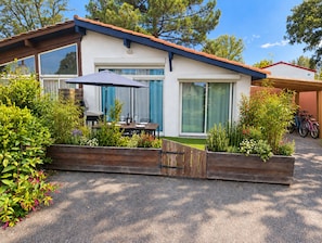 A modern house with a patio, a barbecue grill, and a bicycle parked outside. - New Listing (Soustons)