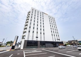 Un hotel moderno con una entrada destacada y varios pisos.