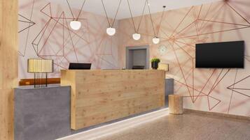 Un mostrador de recepción con detalles de madera, un televisor de pantalla plana montado en la pared y arte geométrico en la pared.
