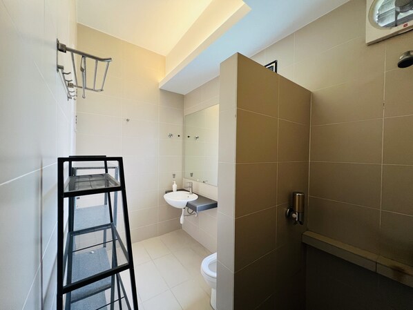 A bathroom with a toilet, sink, and shower area.