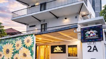 A modern two-story building with a balcony, a mural of sunflowers on the facade, and a sign indicating 'LOT PT 2A'.