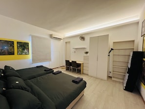 Quarto com cama, escrivaninha, cadeira e guarda-roupa.