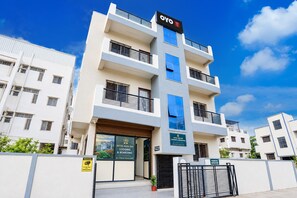 A multi-story hotel with a modern design, featuring balconies, a prominent entrance, and signage for hotel services. - Hotel O Aura Inn (Chhatrapati Sambhajinagar)