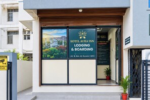A hotel entrance with a sign for 'Hotel Aura Inn' indicating lodging and boarding services, including AC and non-AC rooms and WiFi. - Hotel O Aura Inn (Chhatrapati Sambhajinagar)