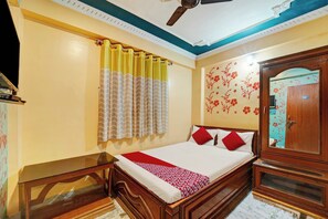 A bedroom with a bed, a wardrobe, a ceiling fan, and a window with curtains. - Hotel O Dream Plaza (Aurangabad - Bihar)