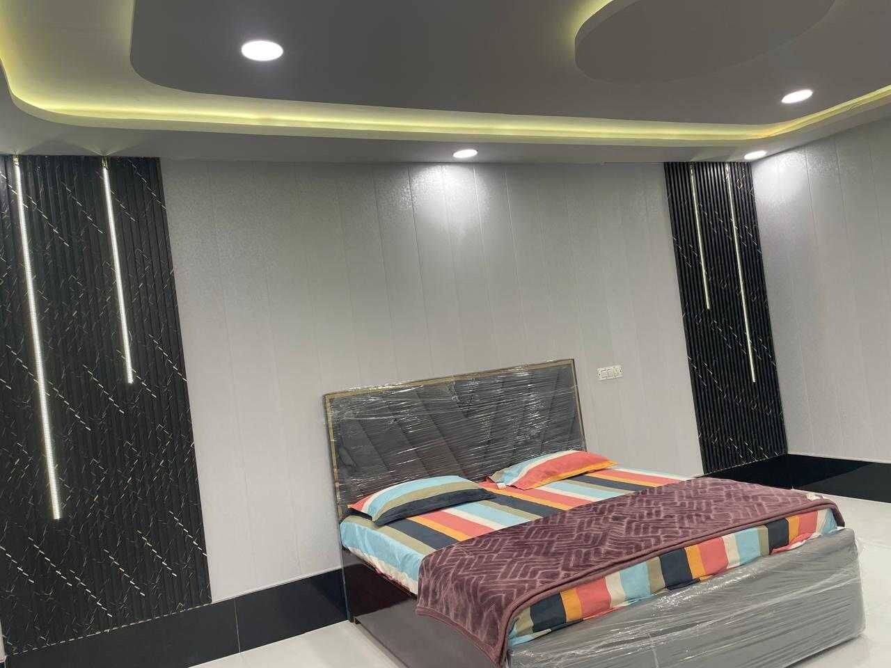 Un dormitorio moderno con cama, cabecera y pared con líneas verticales.