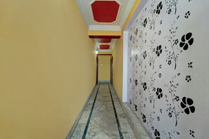 Ein Korridor mit Marmorboden, gelben Wänden und einem floralen Wandpapier.
