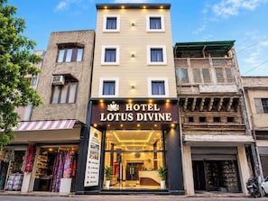 A hotel named 'Hotel Lotus Divine' with a modern facade, a visible reception area, and a storefront with colorful fabrics. - Hotel O Lotus divine (Amritsar)