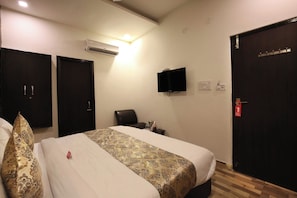 A hotel room with a bed, a chair, a TV, and a door. - Hotel O chohan residency (Amritsar)