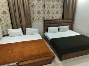 A hotel room with two beds, each with white bedding and a brown headboard. - Hotel O CSJS International (Amritsar)