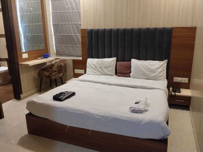 A hotel room with a bed, a desk, a chair, and a window. - Hotel O CSJS International (Amritsar)