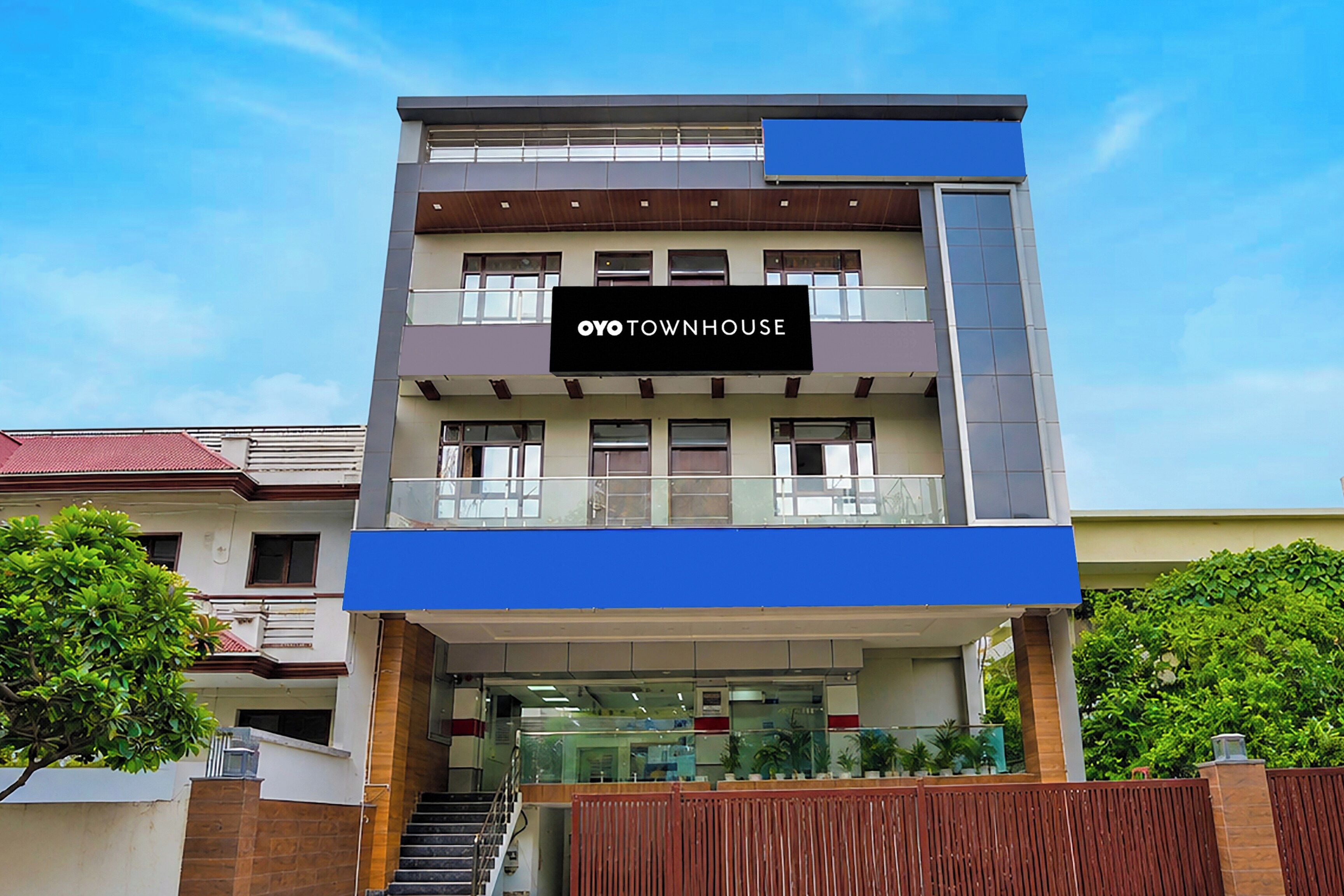 Un edificio de varios pisos con un cartel que dice 'OYO TOWNHOUSE'.