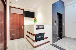 A reception desk with a sign reading 'Reception' and 'OYO TOWNHOUSE'. - Townhouse Hotel SRV inn (Lucknow)