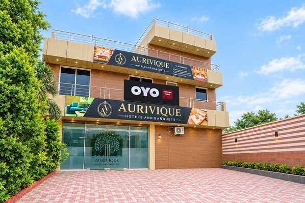 A hotel with a prominent sign for Aurivique Hotels and Banquets, featuring a logo and contact information. - Hotel O Aurivique hotels and Banquets (Lucknow)